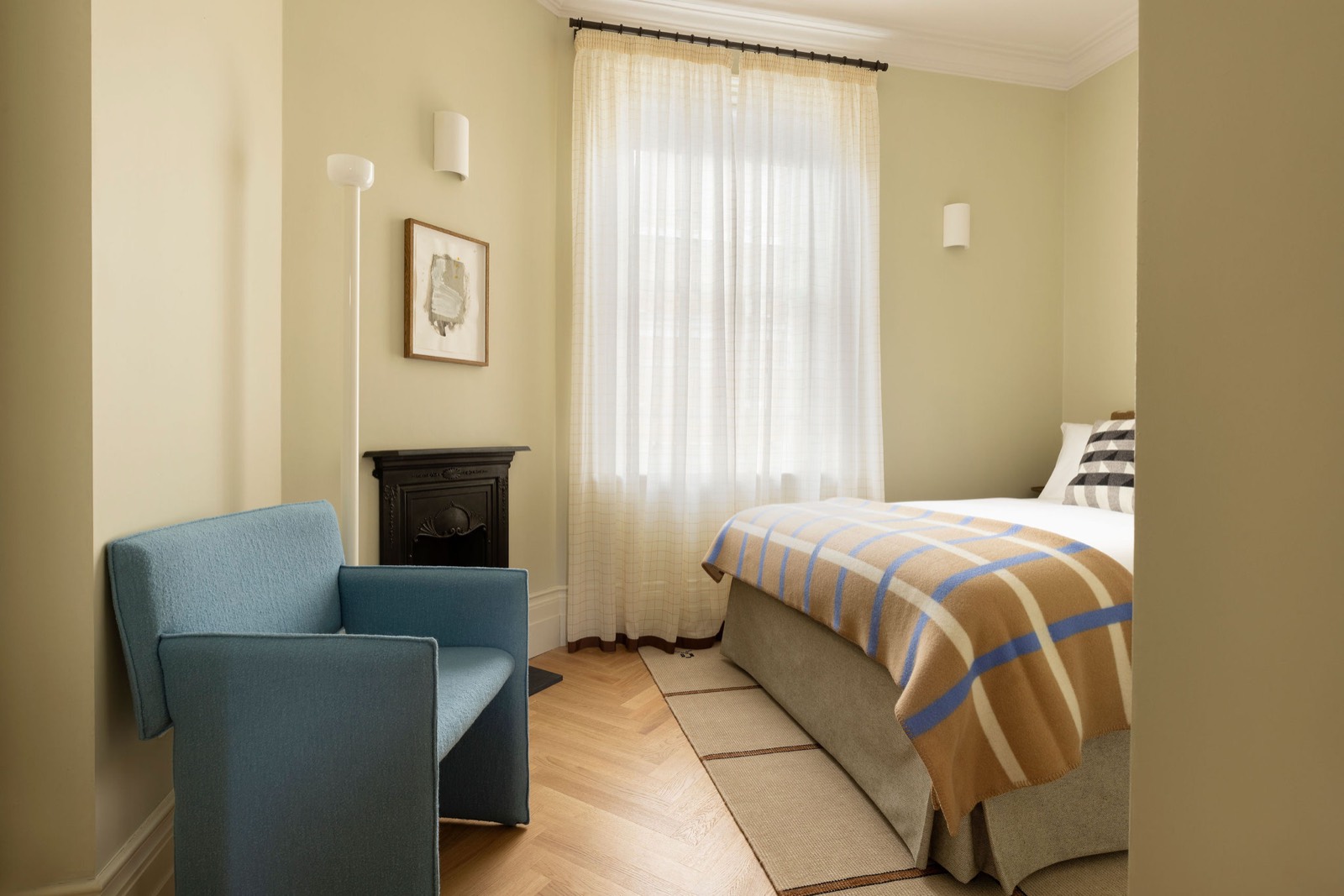 Bedroom with cast-iron fireplace and armchair