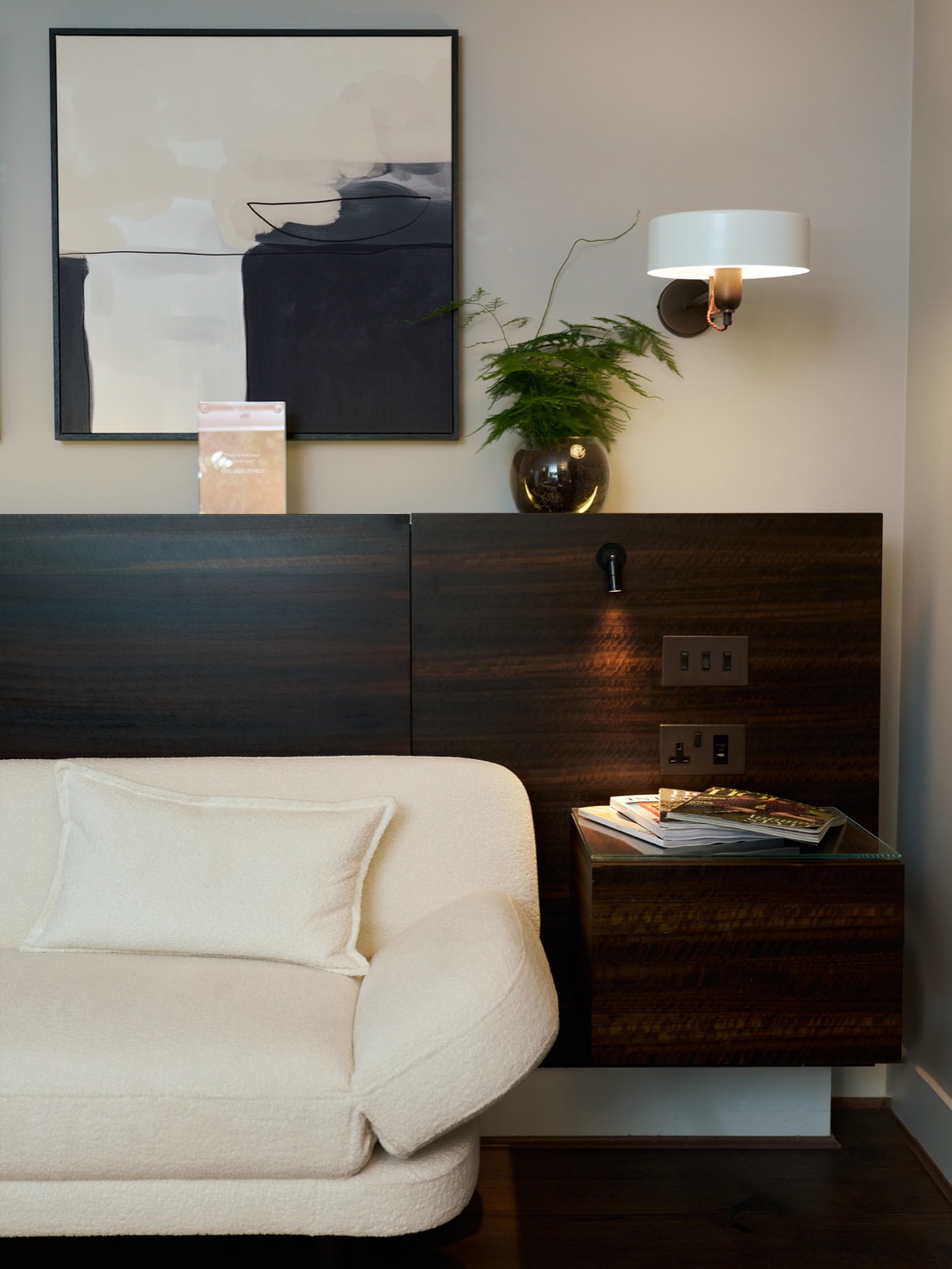 Boucle sofa beneath framed abstract artwork
