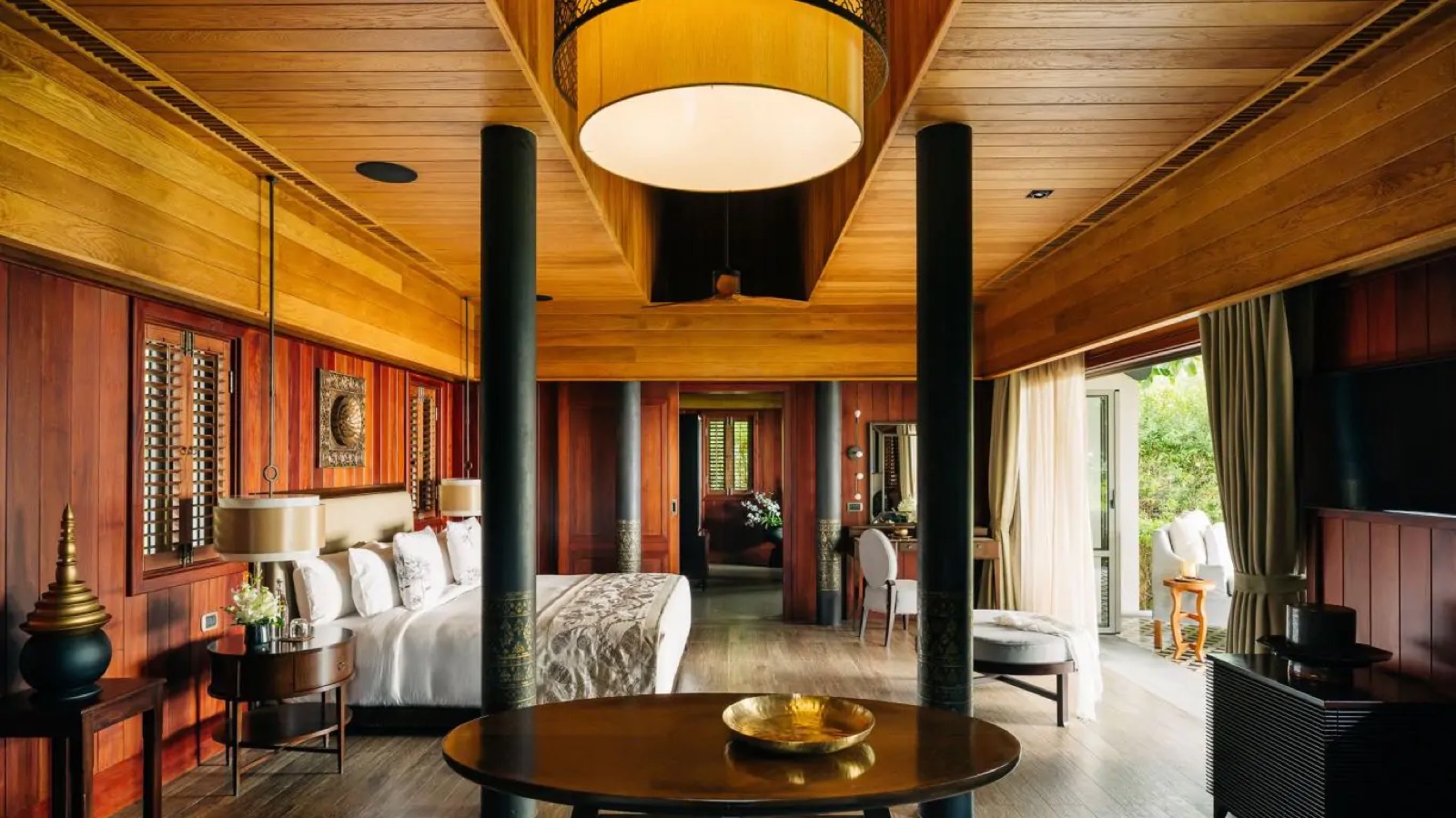 Timber-panelled bedroom with black lacquered columns
