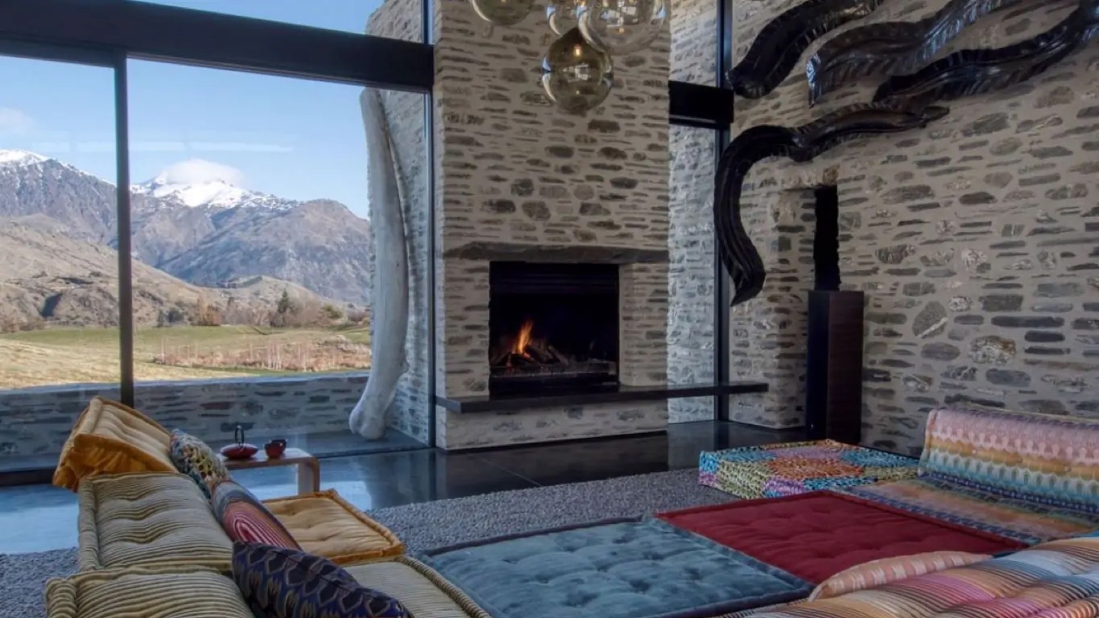 Fireplace and mountain views through full-height glass