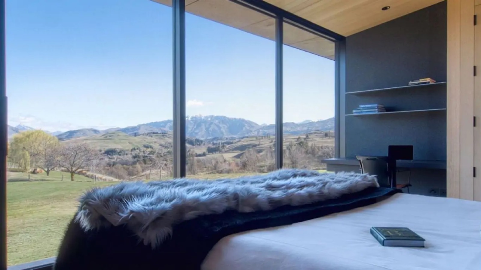Bed facing the valley through full-height glass