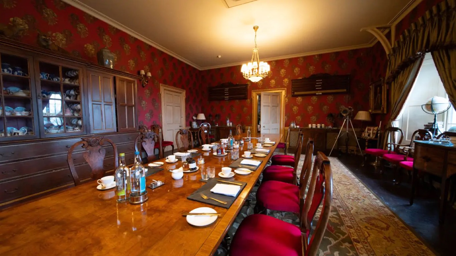 Long dining table set beneath the chandelier