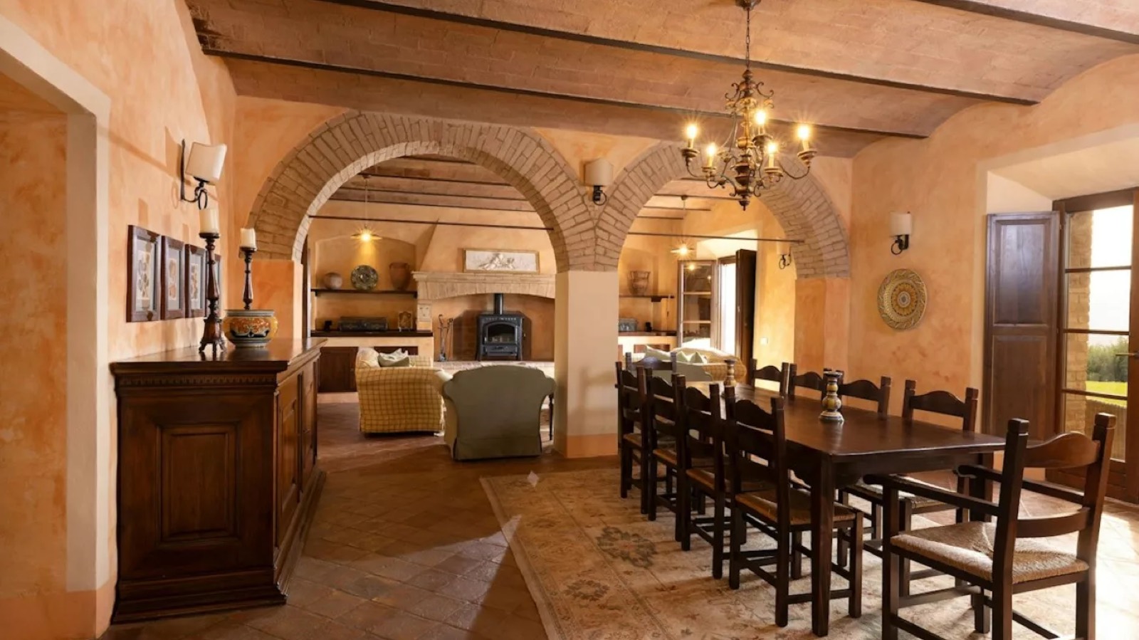 Dining room with long table beneath brick arches