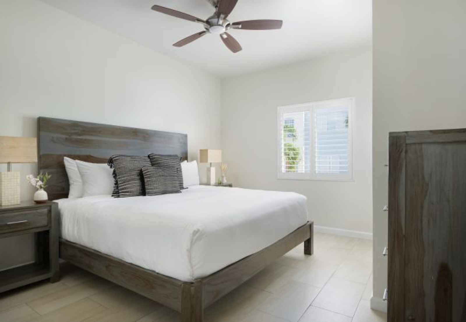 King bedroom with timber headboard and shutters