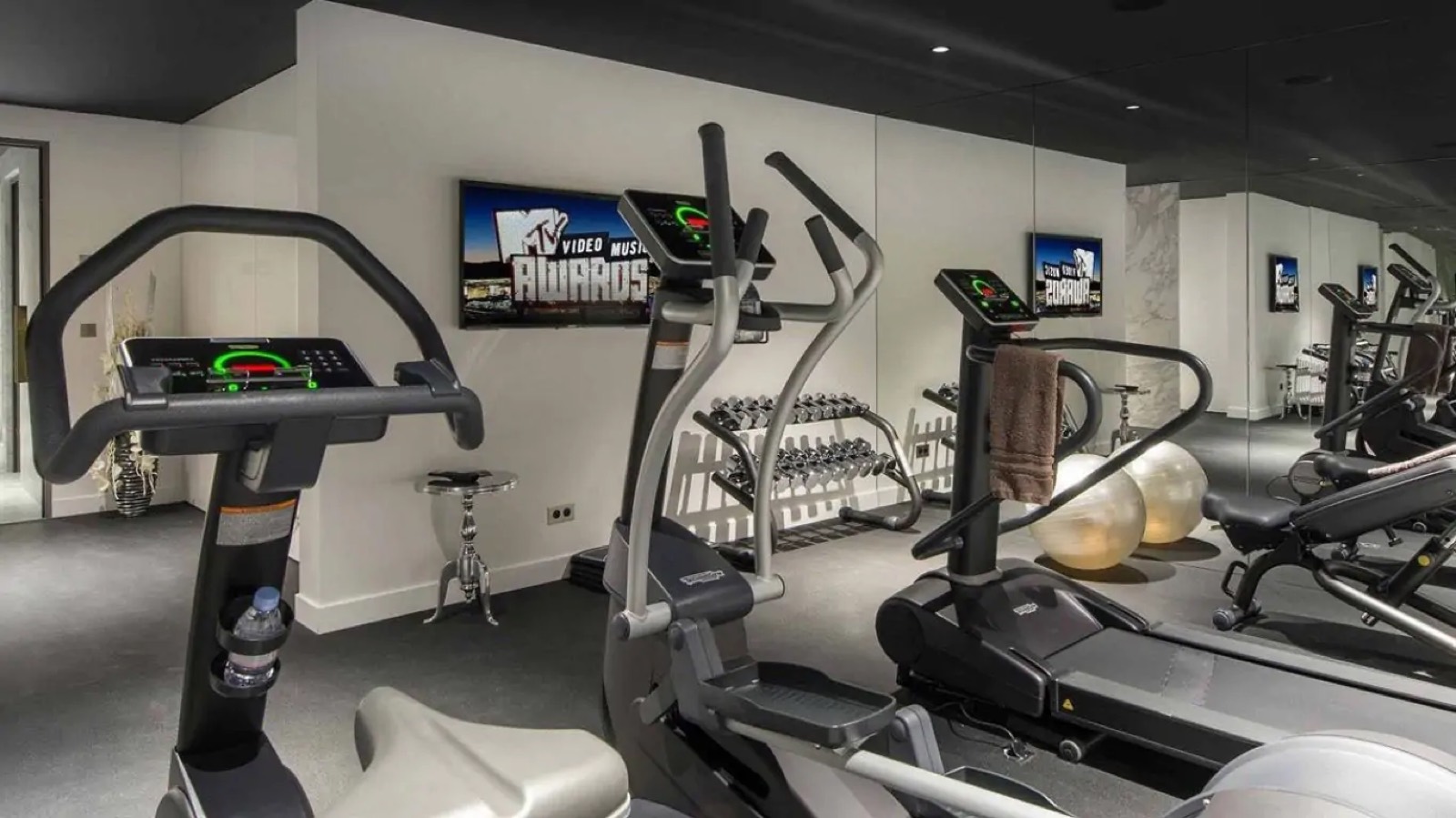 Gym with cardio machines and mirrored wall