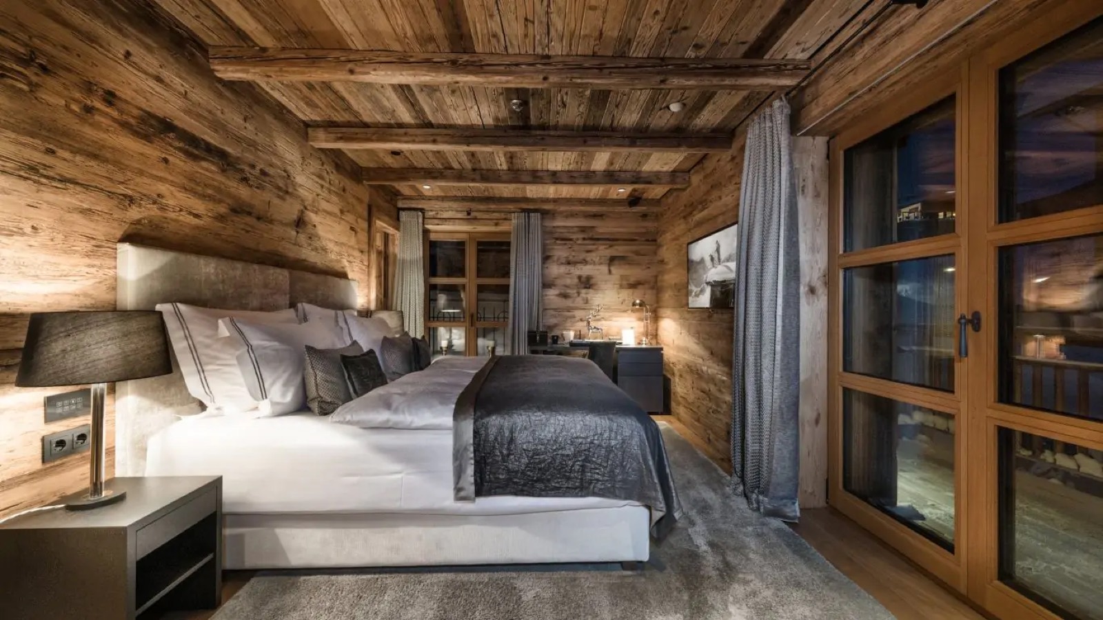Bedroom under low timber beams with balcony doors