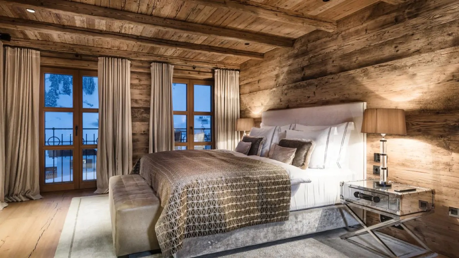 Bedroom with patterned throw and twin balcony doors