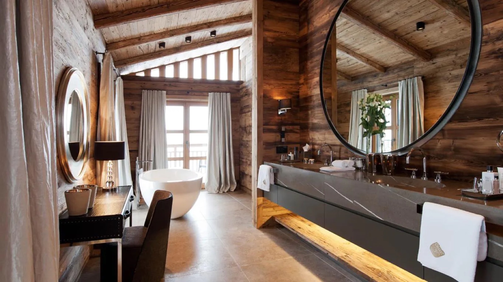 Bathroom with freestanding tub and round mirror