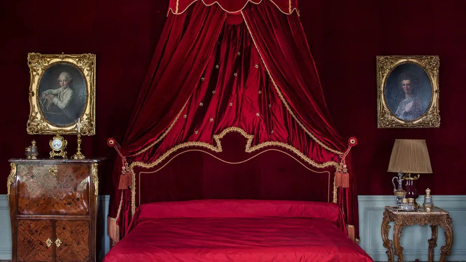 Bedroom with crimson velvet canopied bed