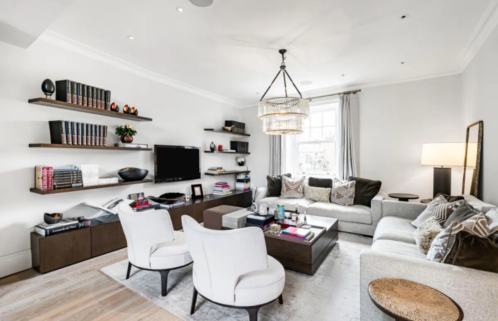 Sitting room with shelved wall and television