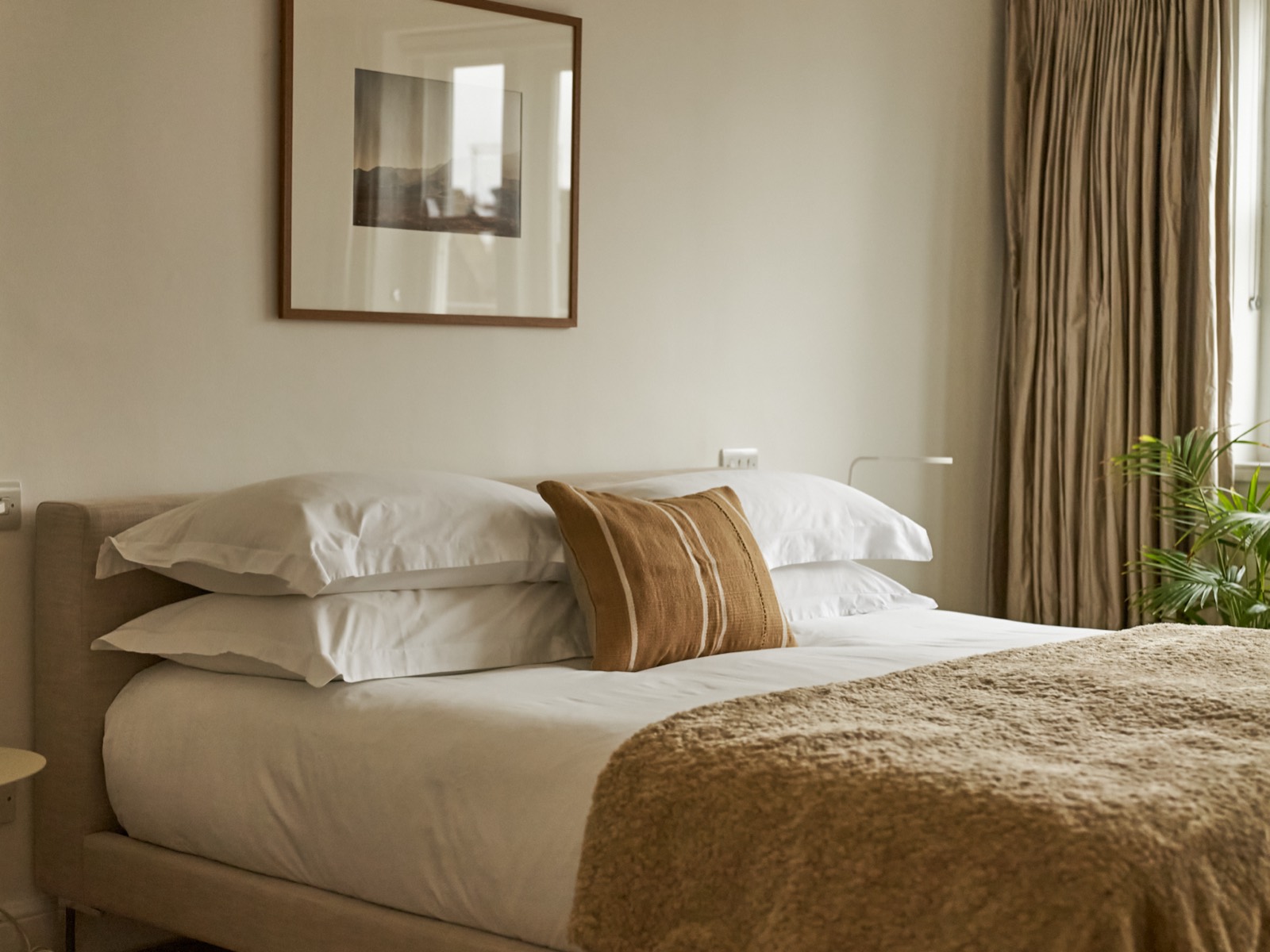 Bed corner with floor-length curtains