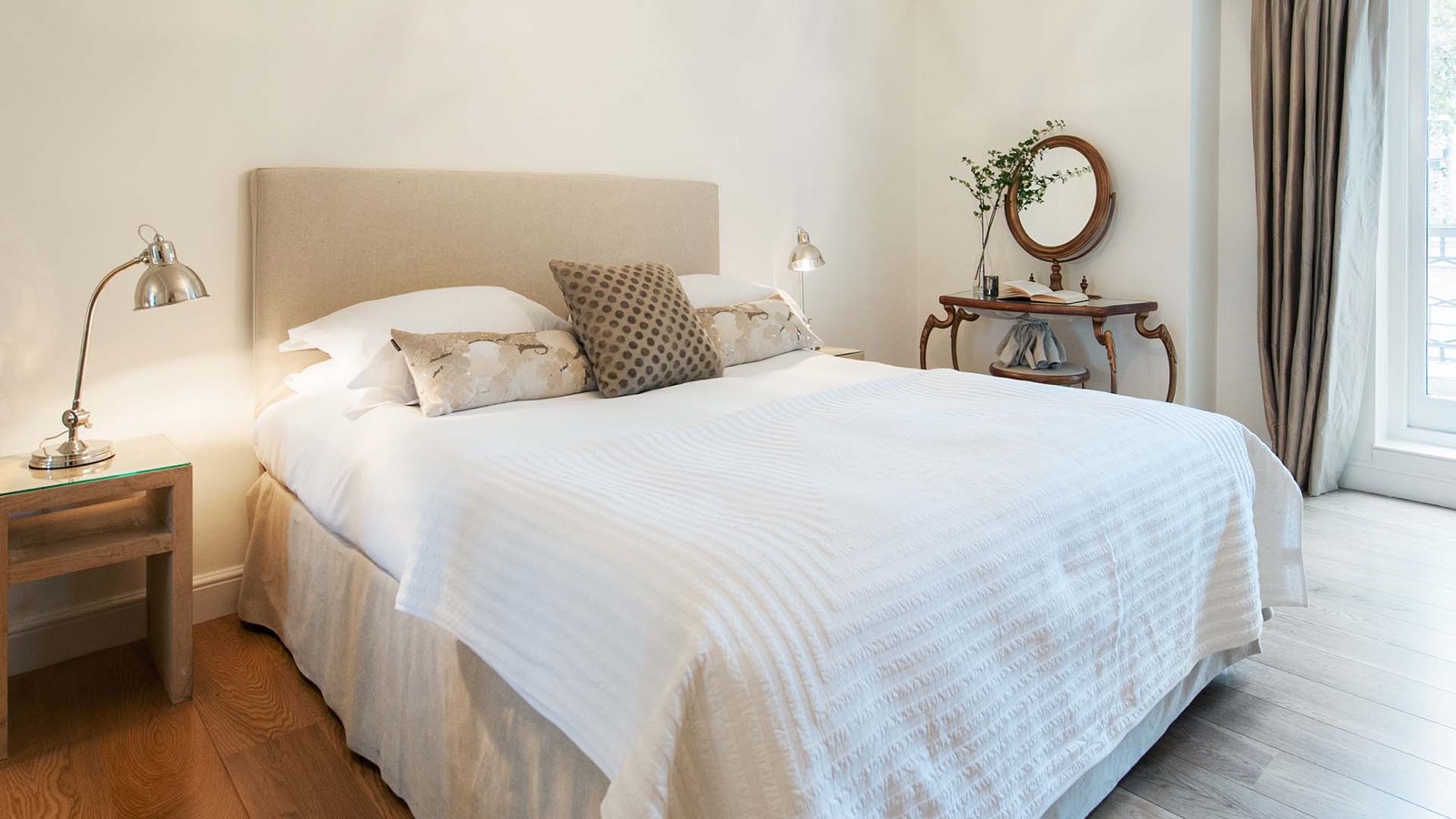 Bedroom with linen headboard and gilt console