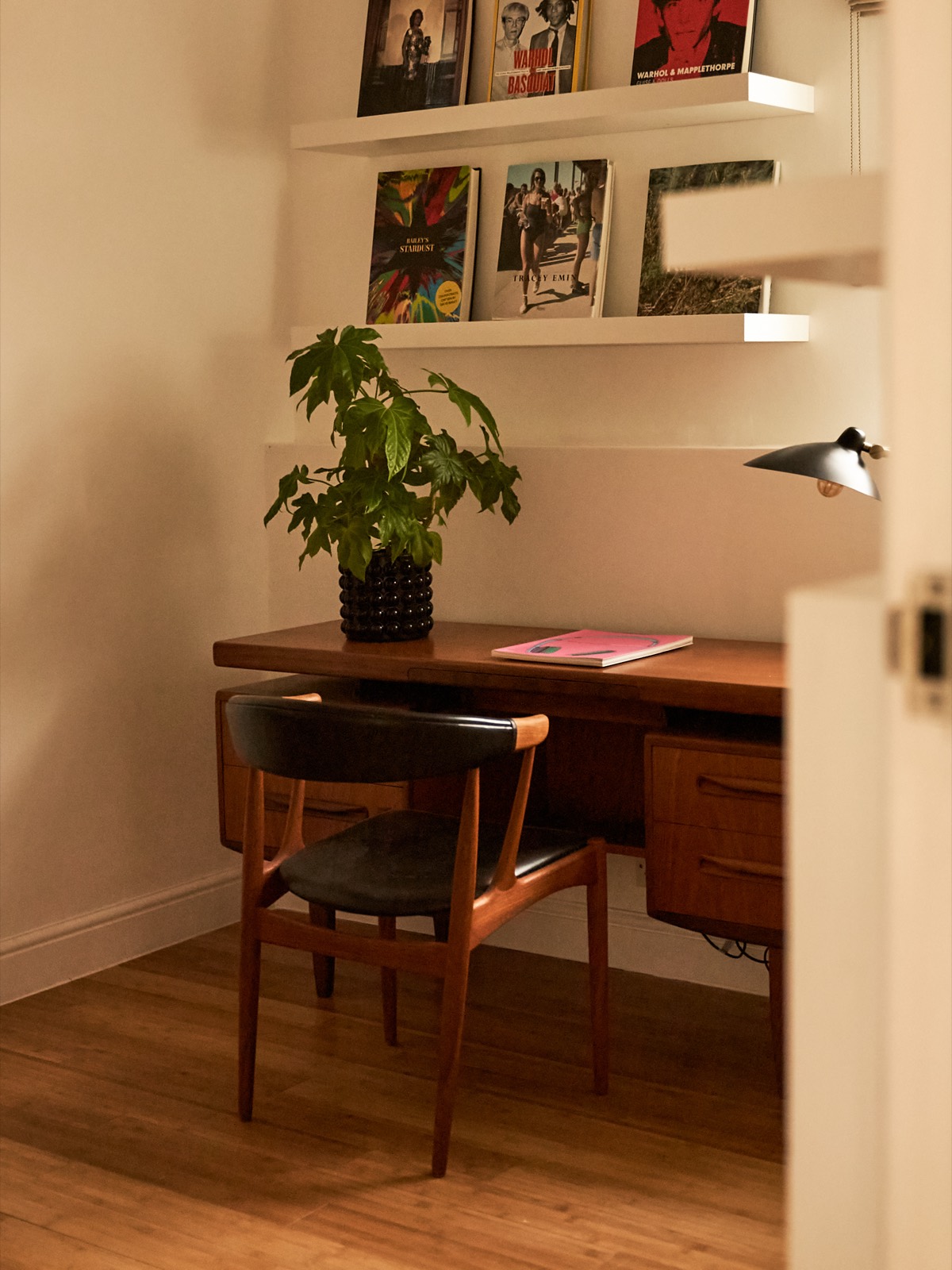 Writing desk with art books above