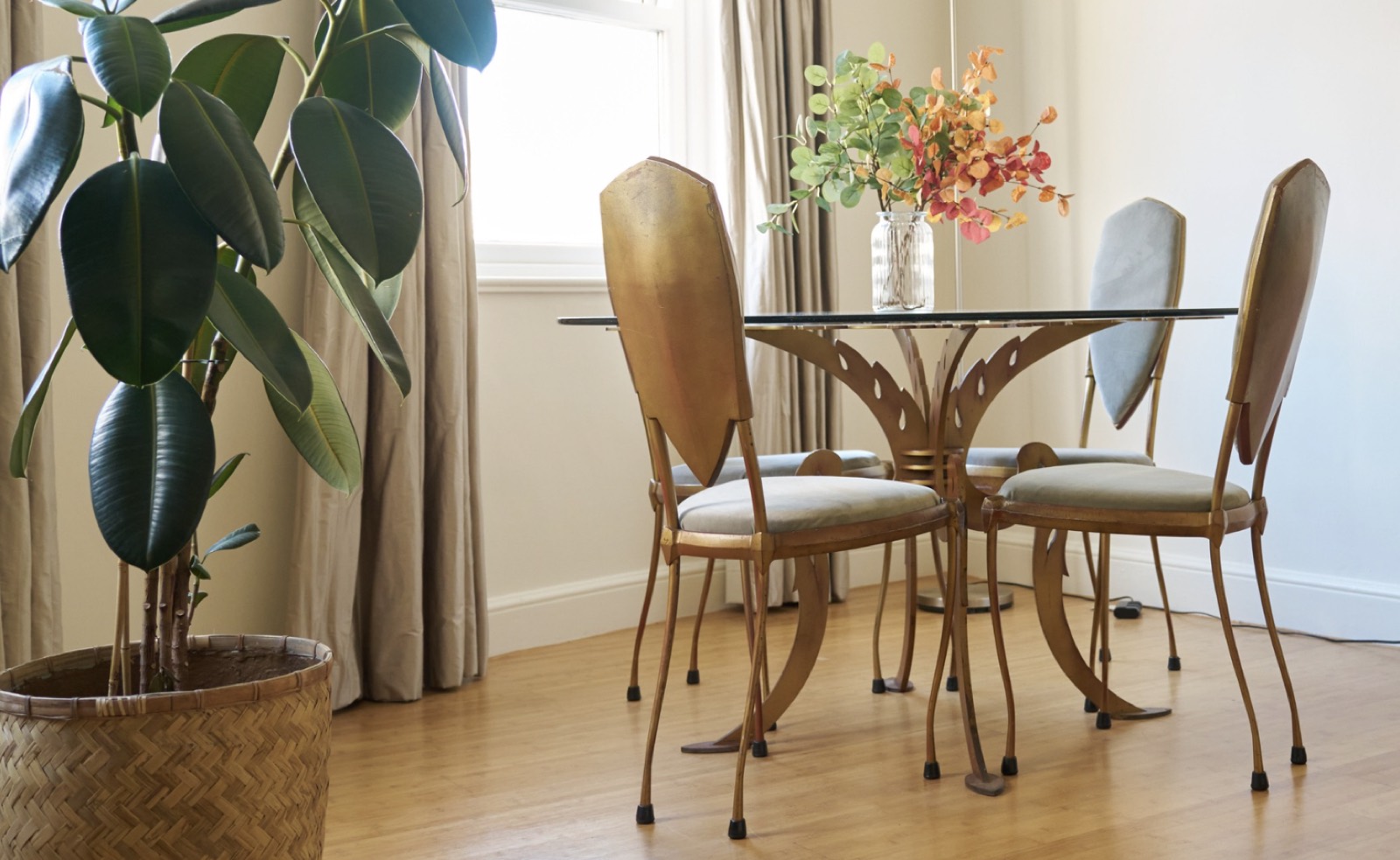 Dining table with gilt chairs by the window