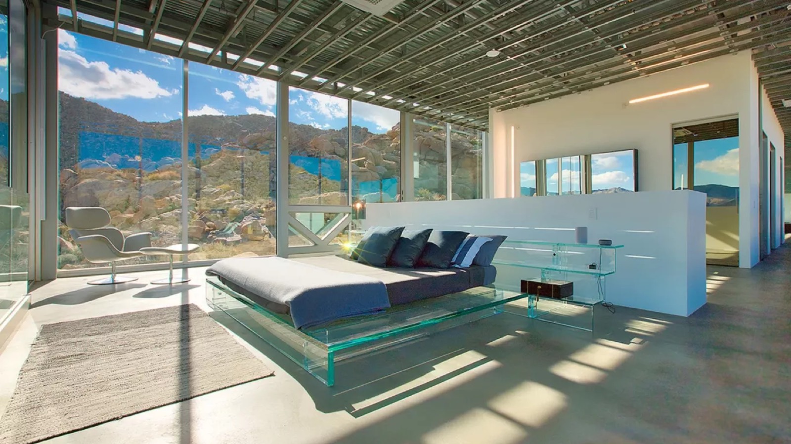 Bedroom with glass bed frame facing the desert