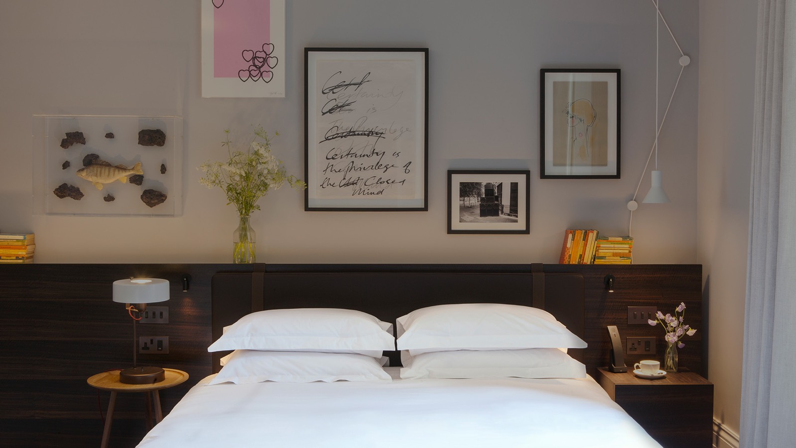 Bed framed by artwork and vintage curiosities