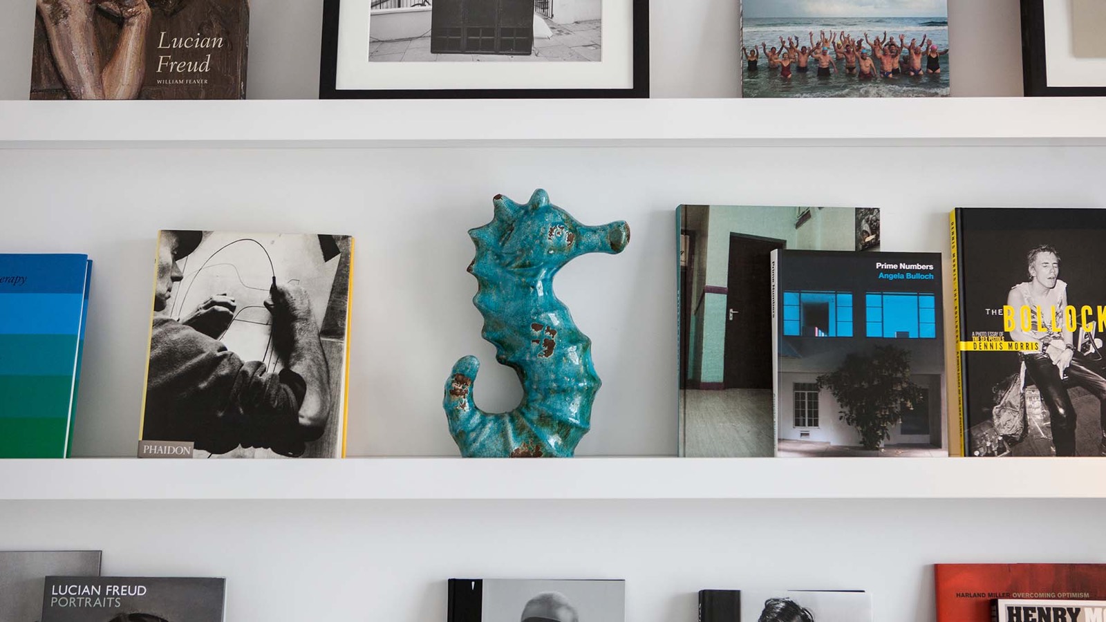 Art books and a ceramic seahorse
