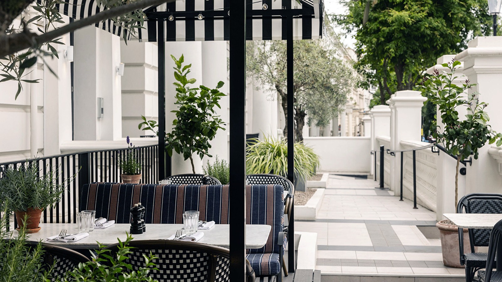 Terrace tables beneath a striped awning
