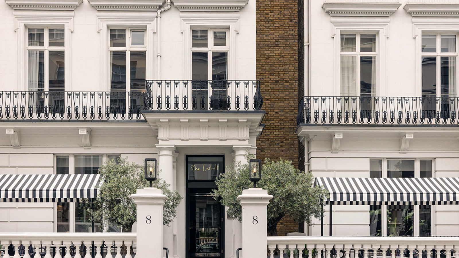 White townhouse frontage with striped awnings