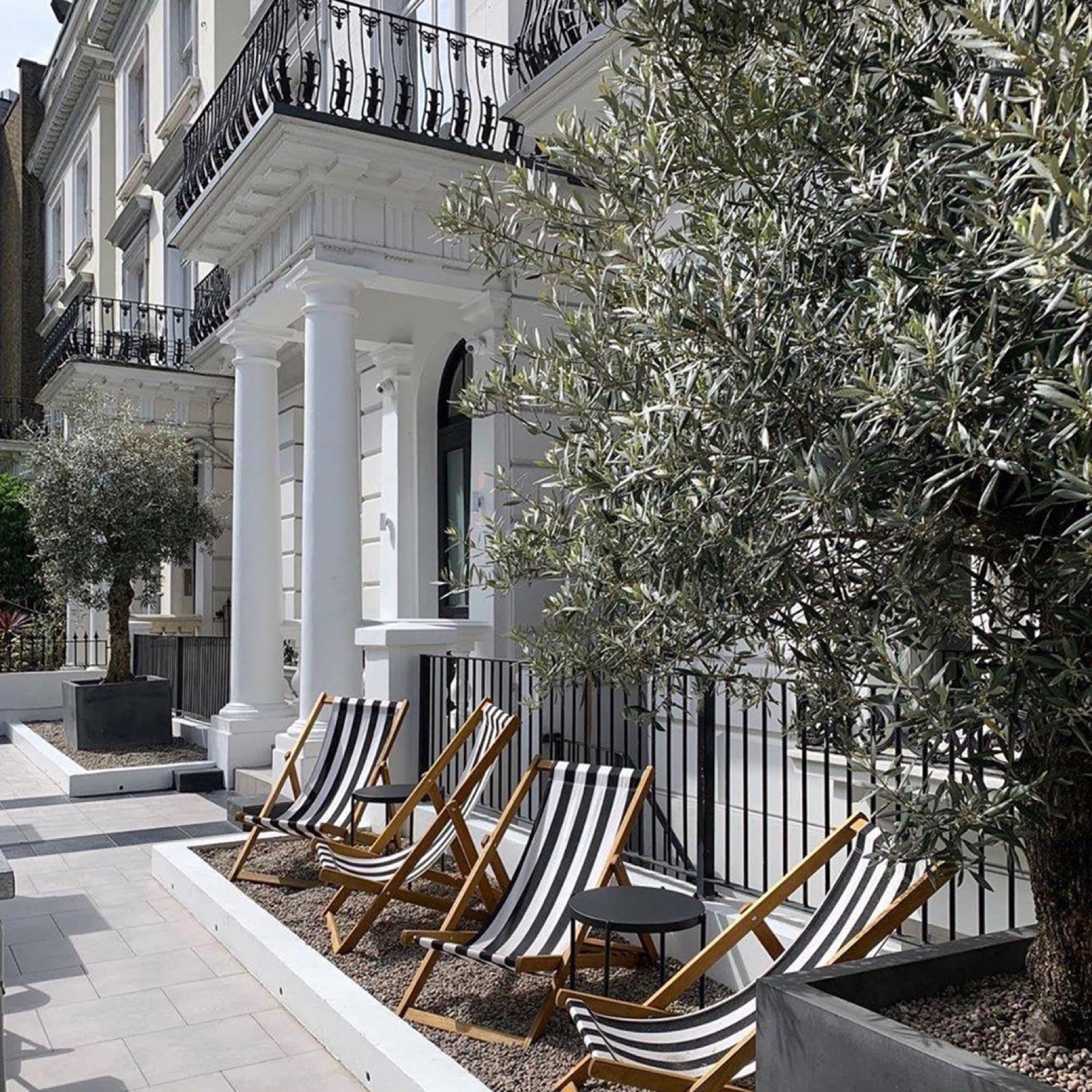 Striped deckchairs and olive trees out front