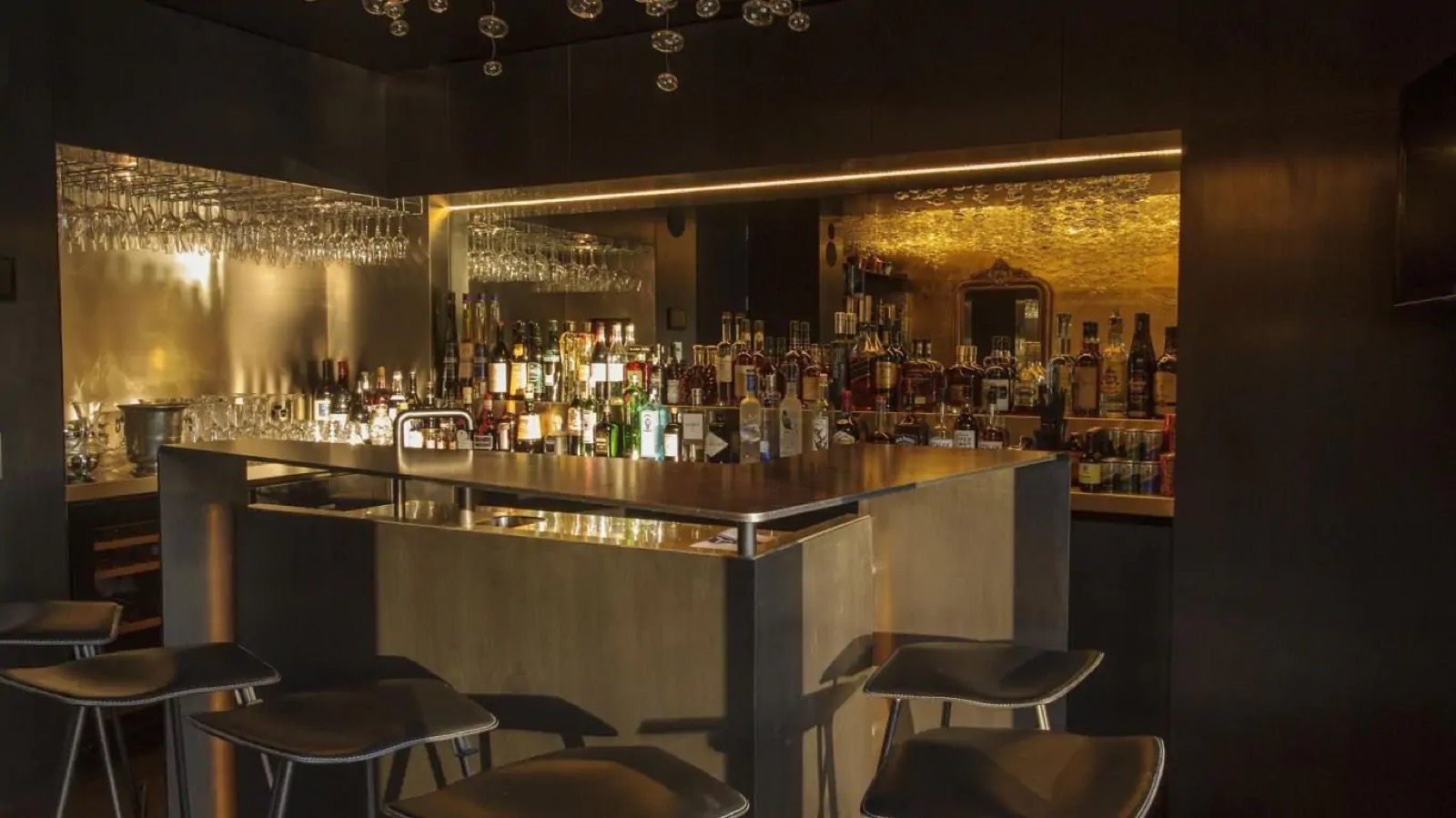 The bar, with stools and backlit shelves