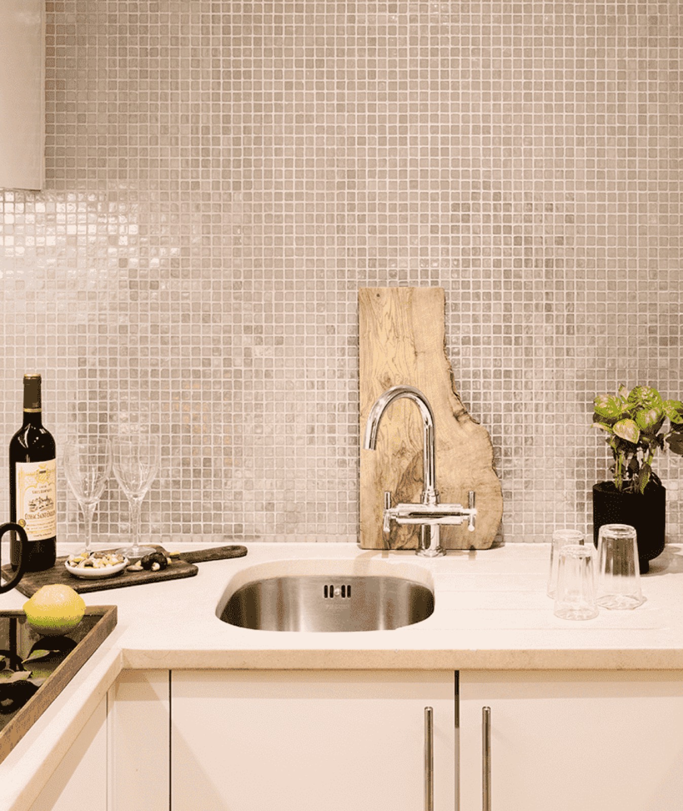 Kitchen sink beneath mosaic tiling