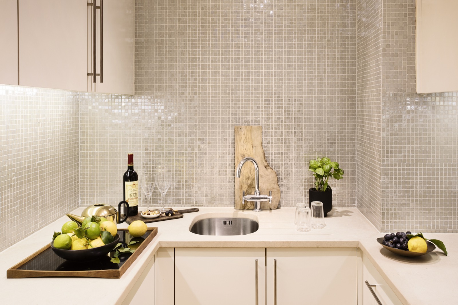 Fitted kitchen with mosaic tiled splashback