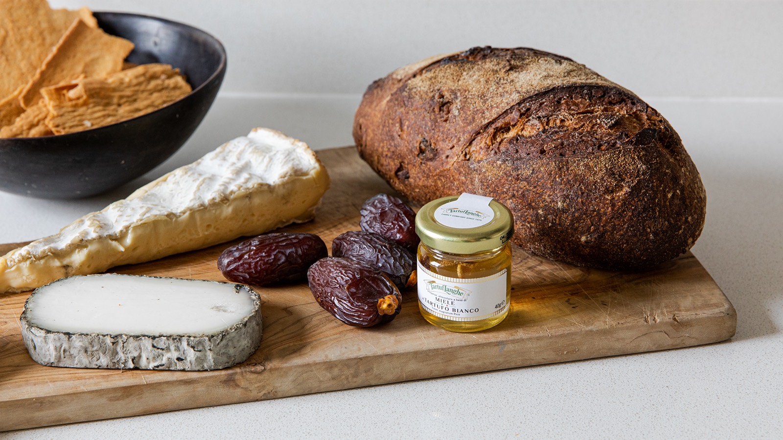 Cheese, bread and honey on an olive board