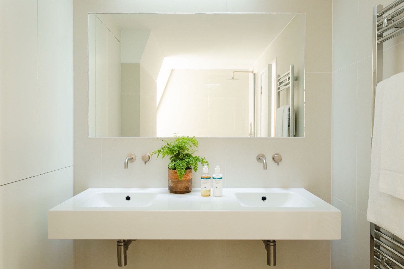 Twin basins beneath a wide mirror