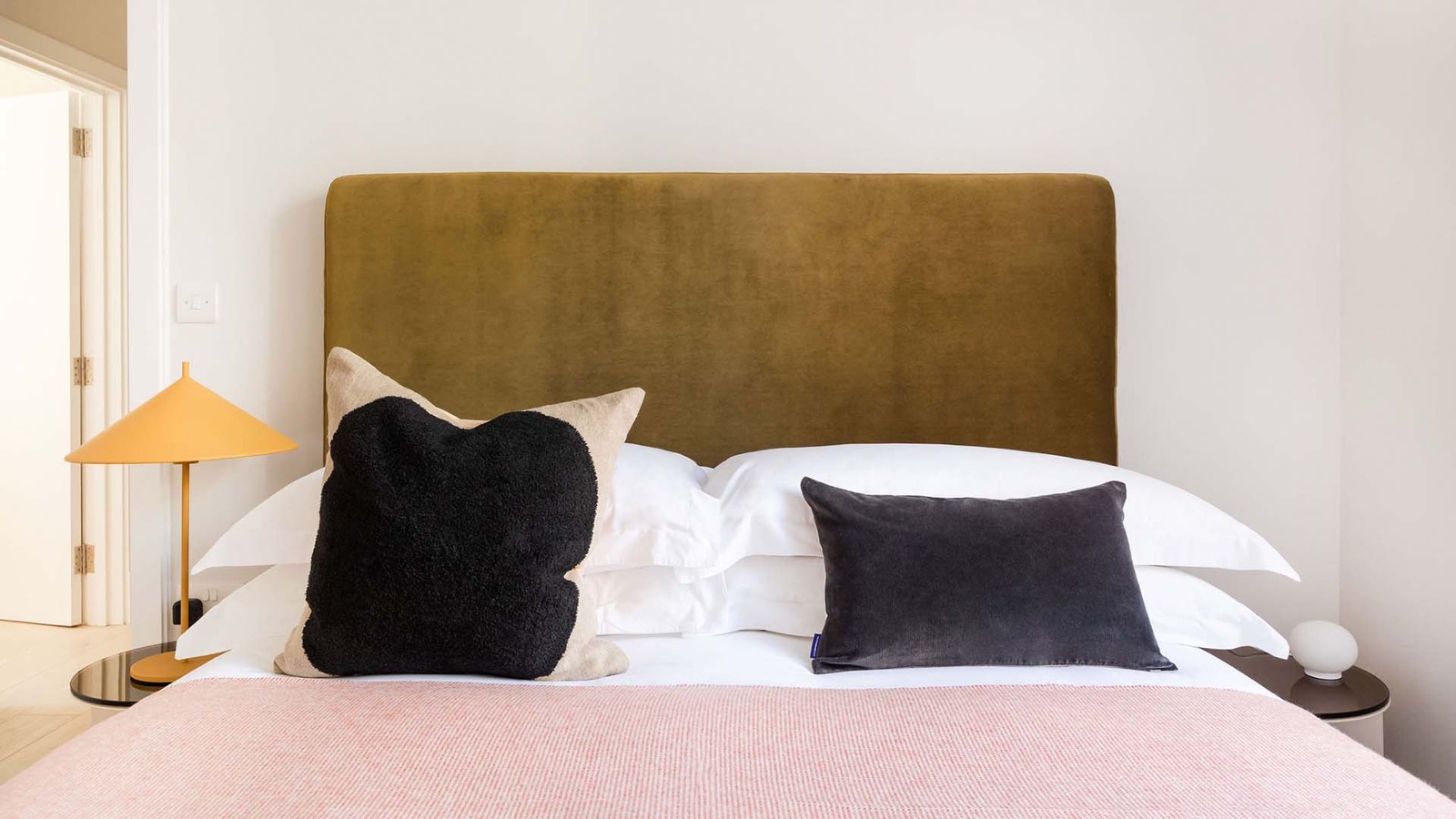 Principal bedroom with olive velvet headboard