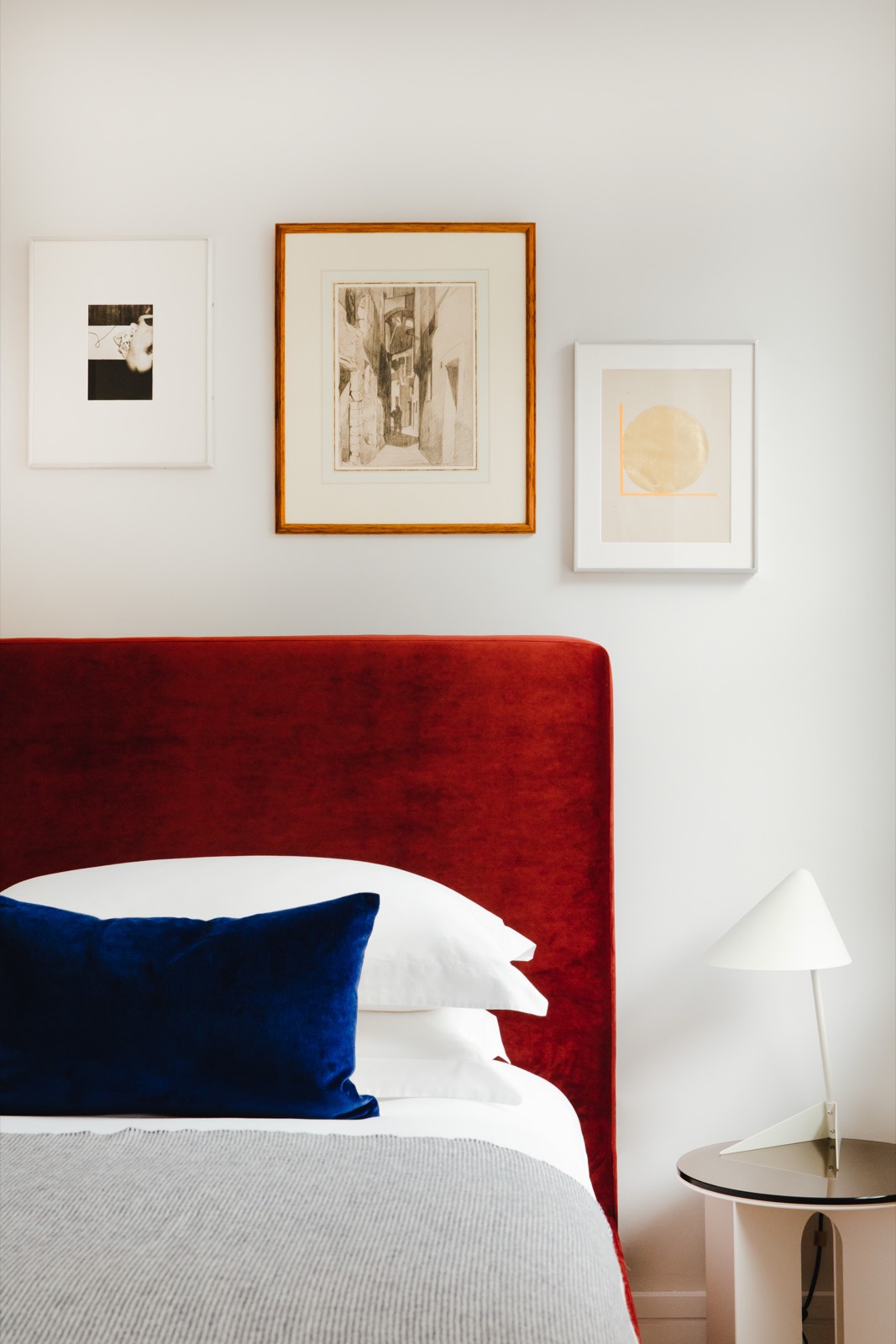 Framed prints above the velvet headboard