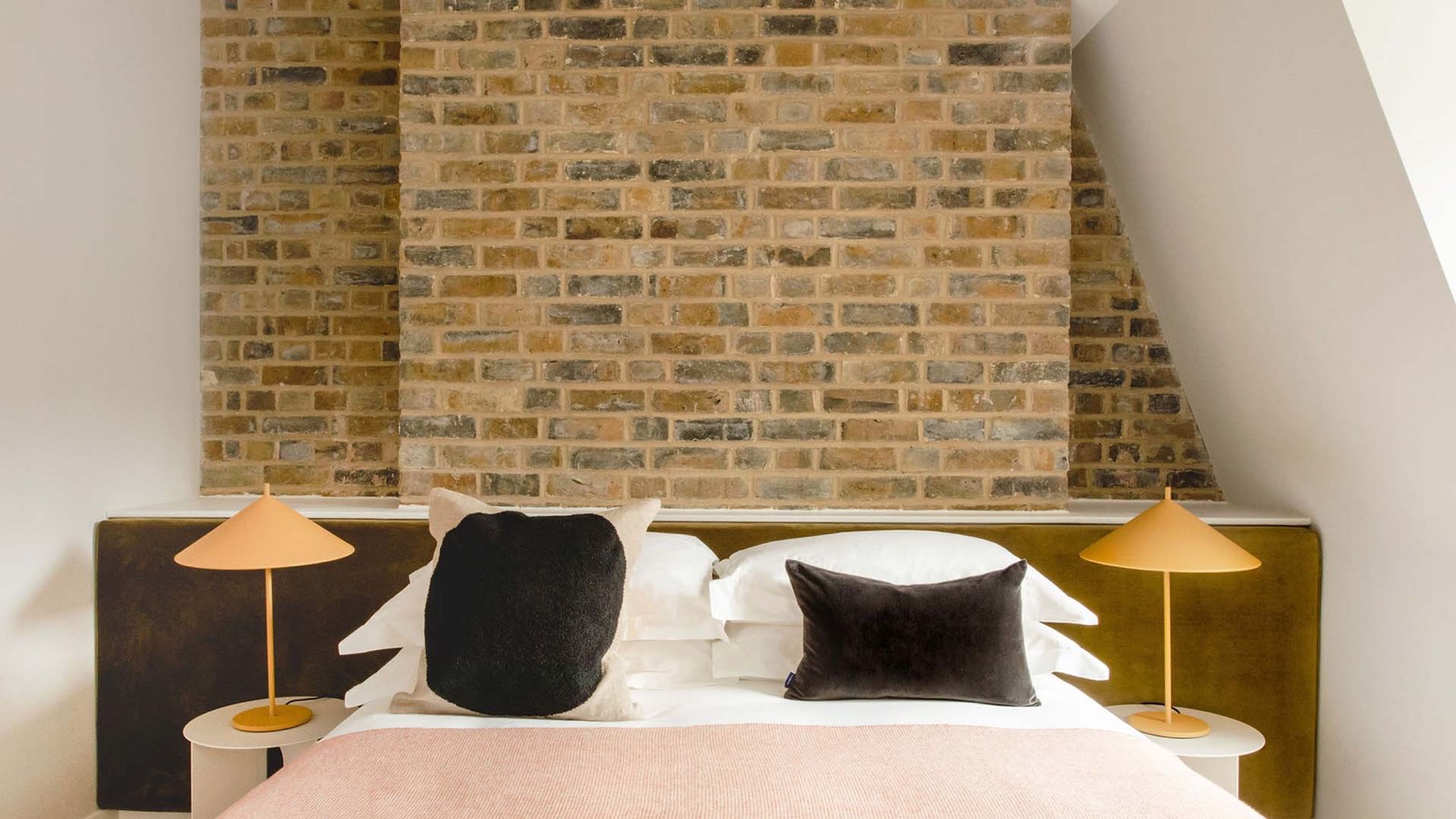 Bedroom with exposed brick behind the bed