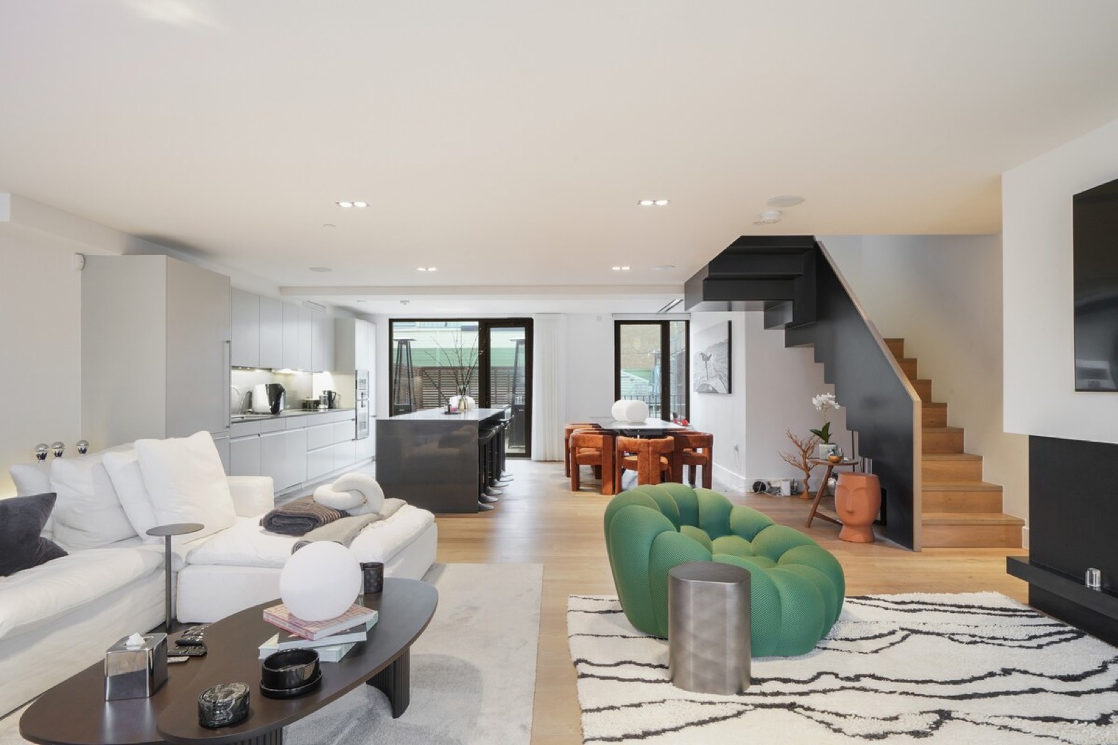 Living space with staircase and kitchen beyond