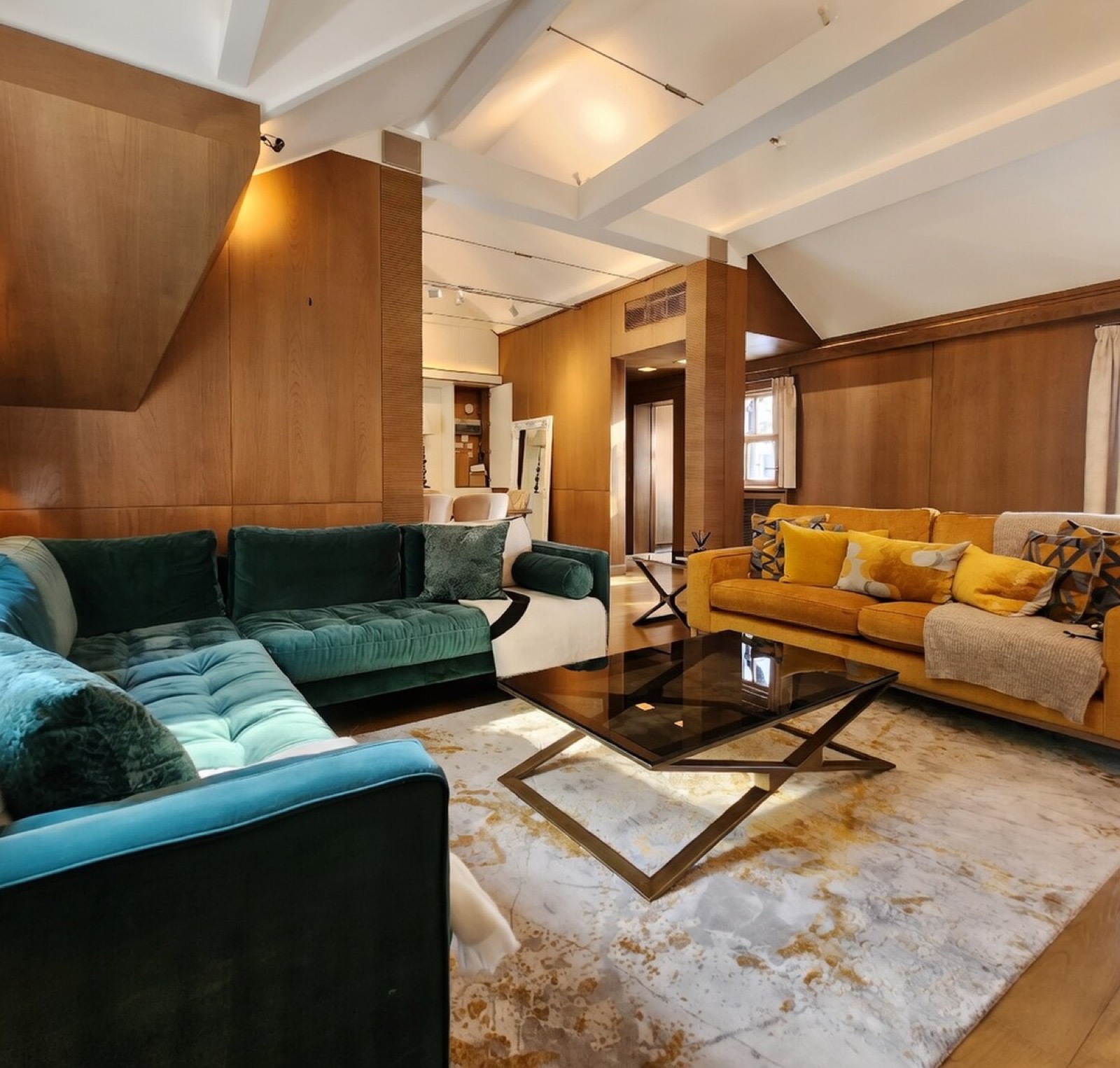 Panelled sitting room with three velvet sofas