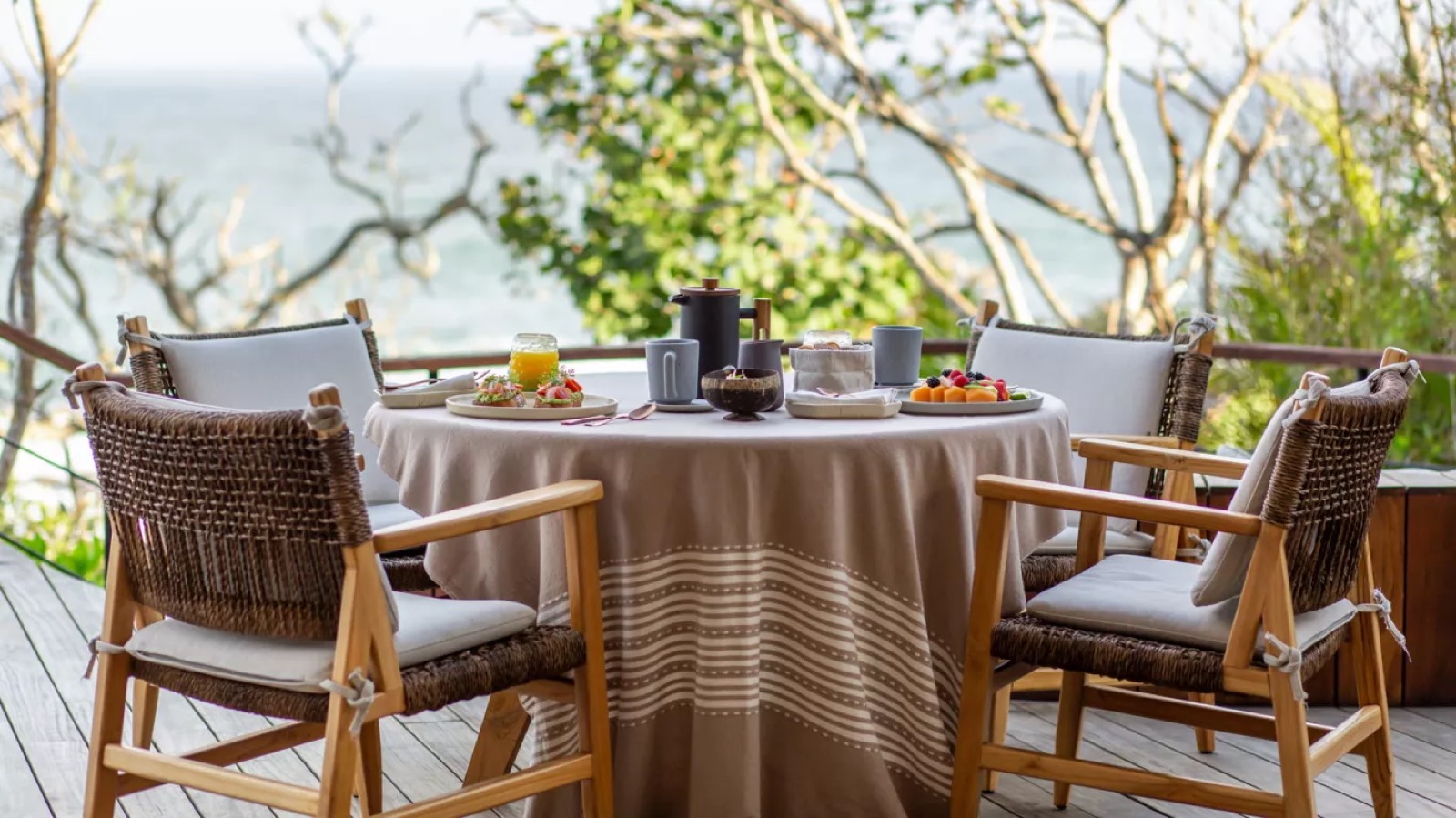 Breakfast set on the deck, sea beyond