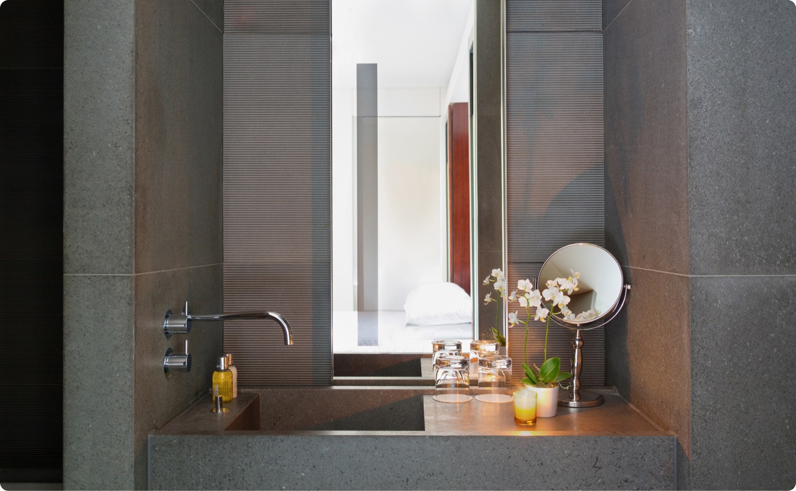 Stone basin with wall-mounted tap