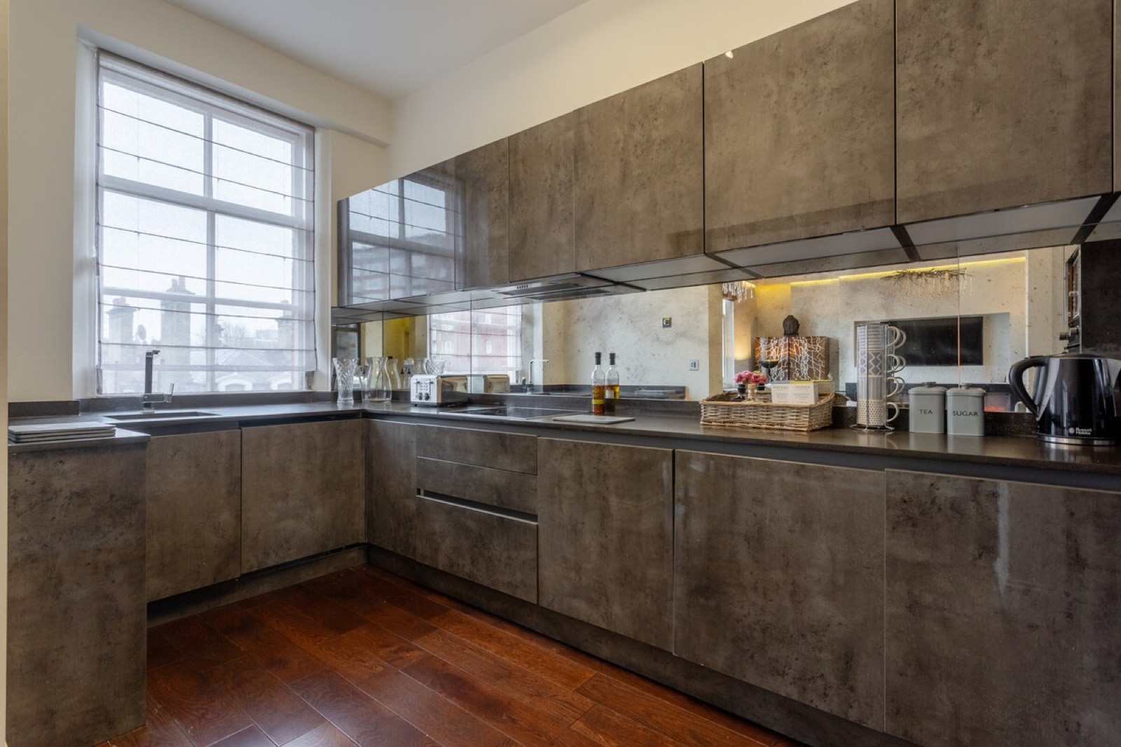 Kitchen with mirrored splashback and stone worktops