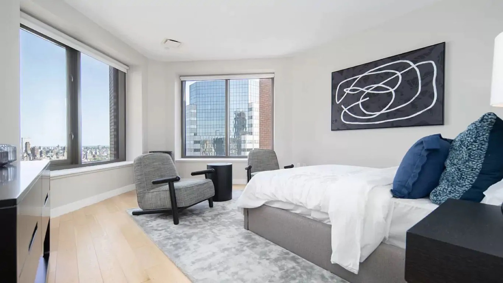 Second bedroom with armchairs and corner windows