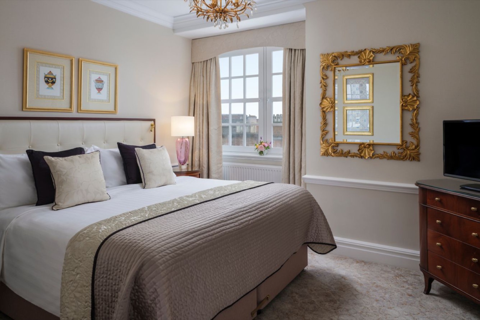 Master bedroom with king bed and gilt mirror