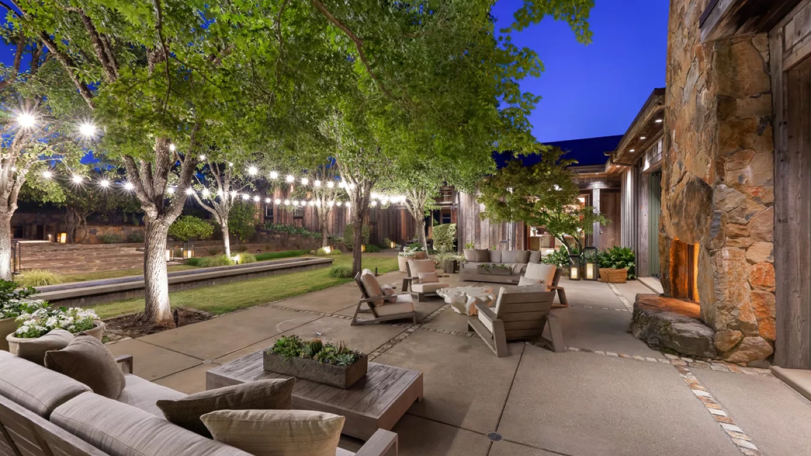 Terrace seating beside the lit outdoor fireplace