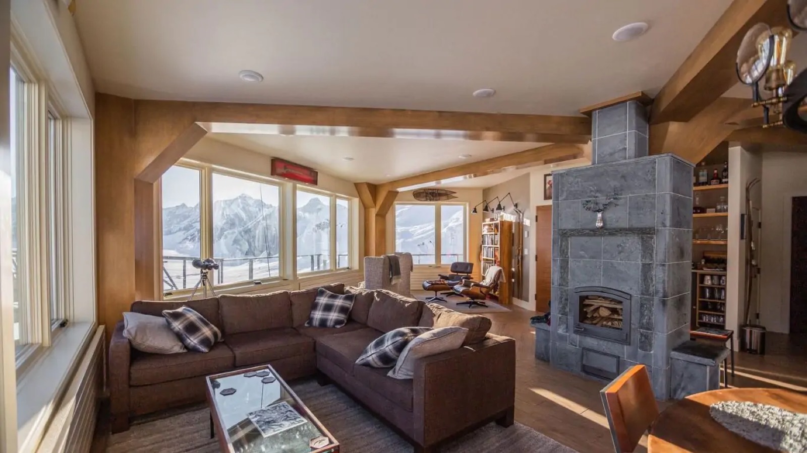 Living room with stone fireplace and mountain windows