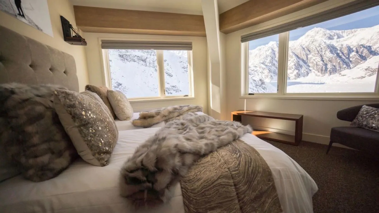 Bedroom with armchair beside the mountain windows