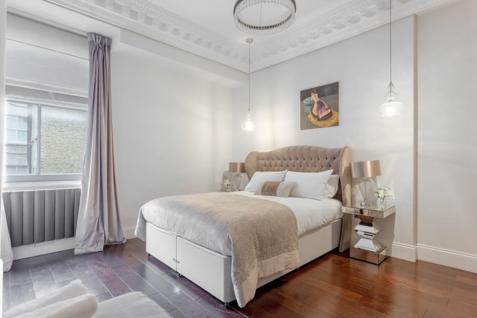 Bedroom with buttoned headboard and mirrored tables