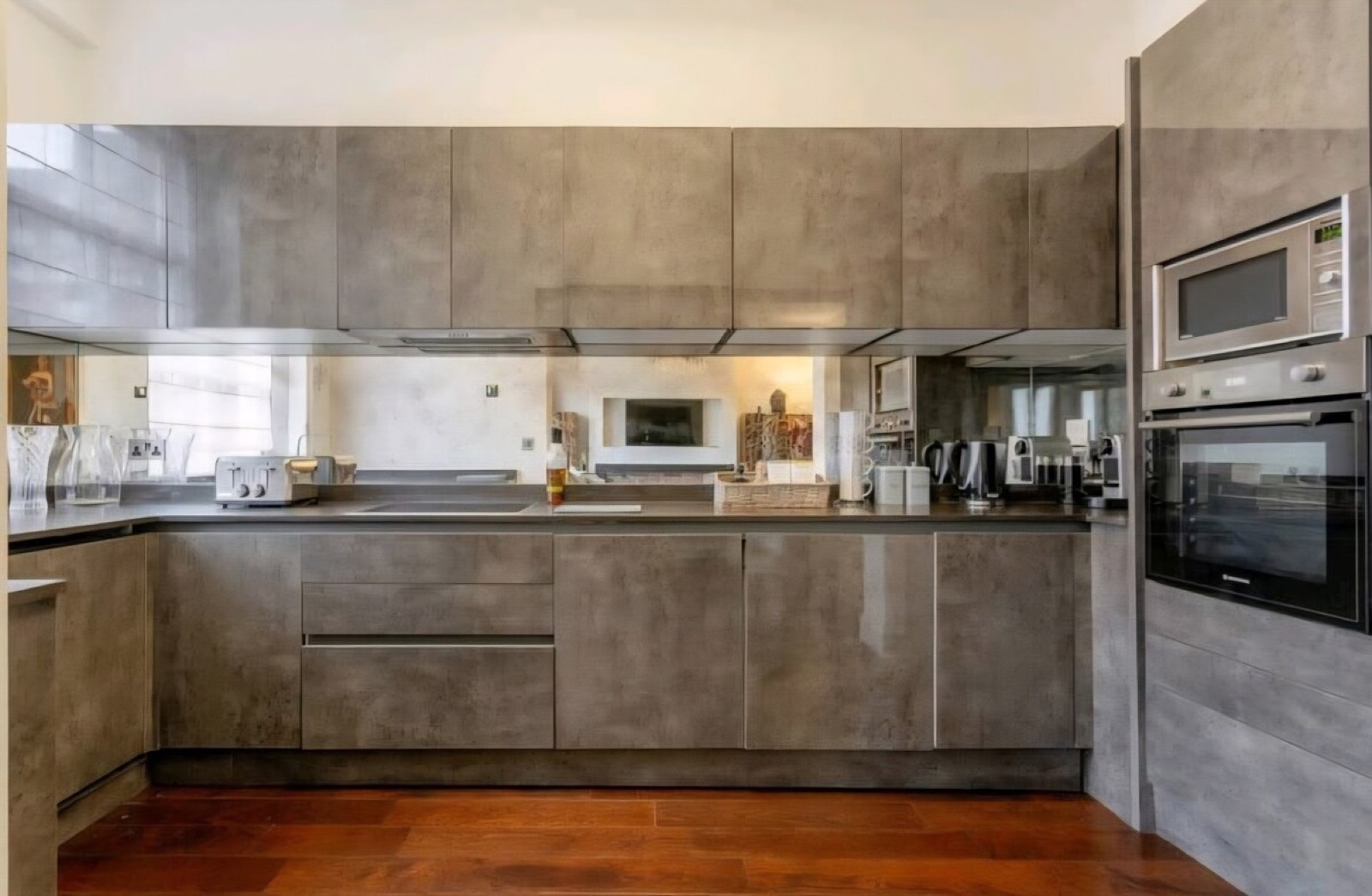 Kitchen with mirrored splashback and built-in ovens