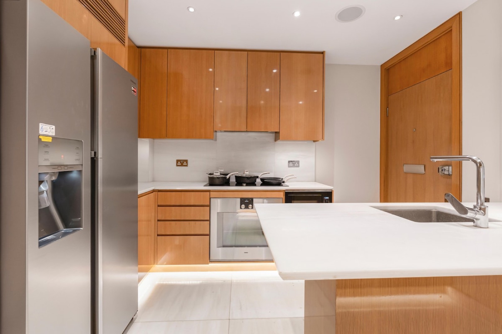 Hob and oven beside the tall fridge