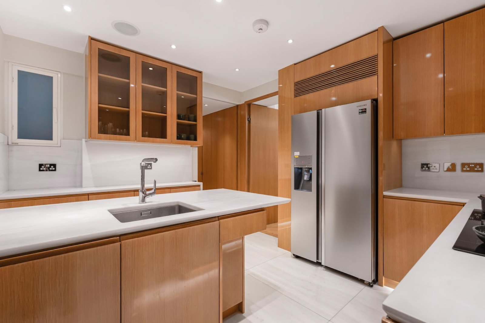 Kitchen sink beneath glazed wall cupboards