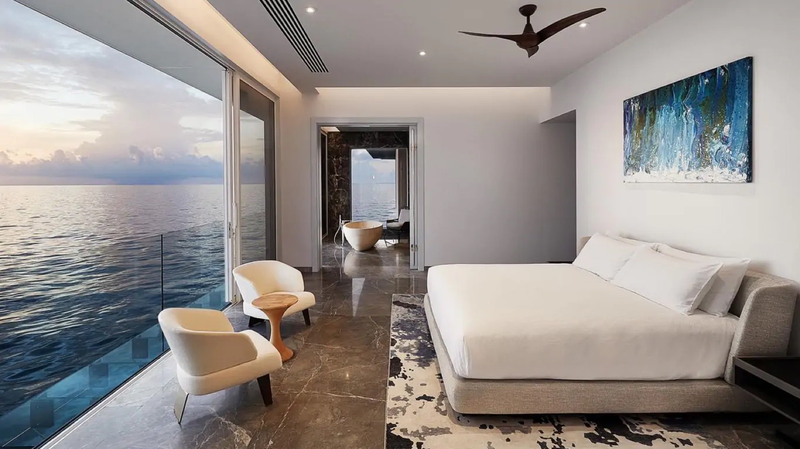 Bedroom with glass wall above the sea