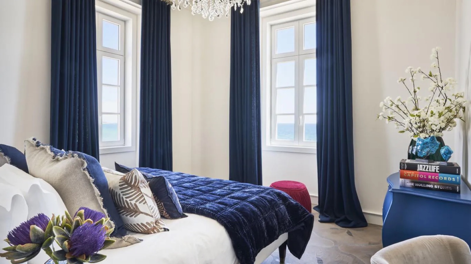 Bedroom in navy with windows to the sea