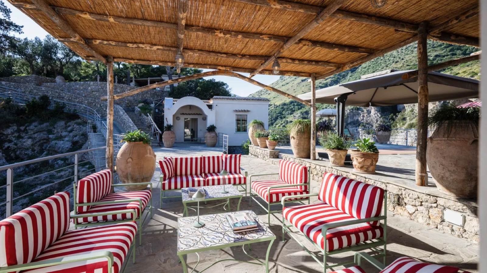 Shaded pergola lounge with striped sofas
