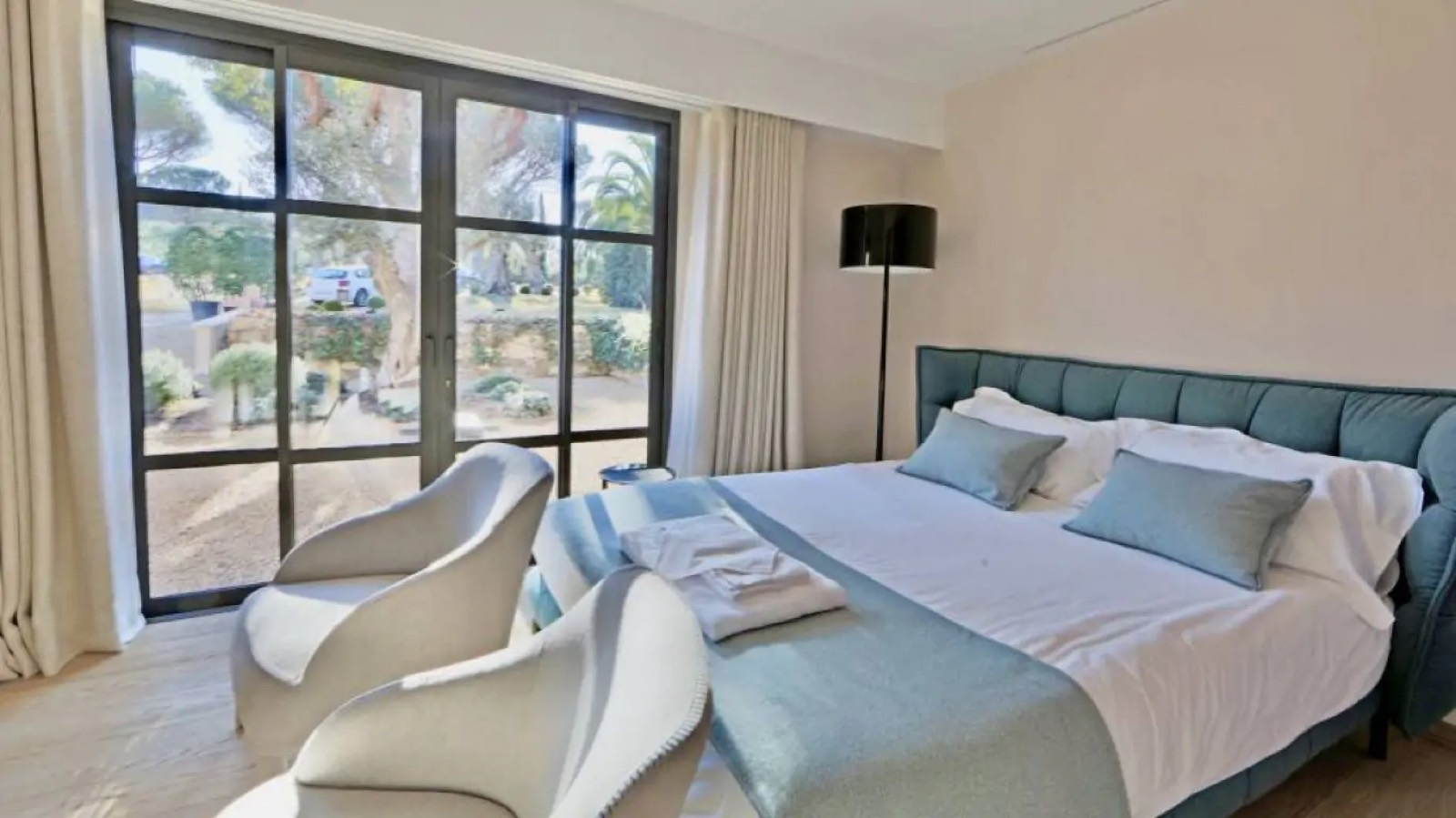 Bedroom with padded headboard and garden doors